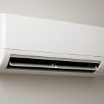 A modern air conditioning unit mounted on a wall in a neutral-colored room.
